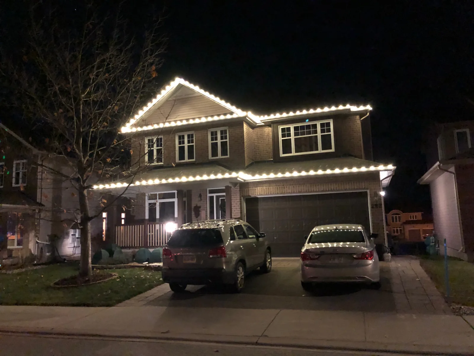 Holiday lighting installed along the gutters and peaks of a residential home